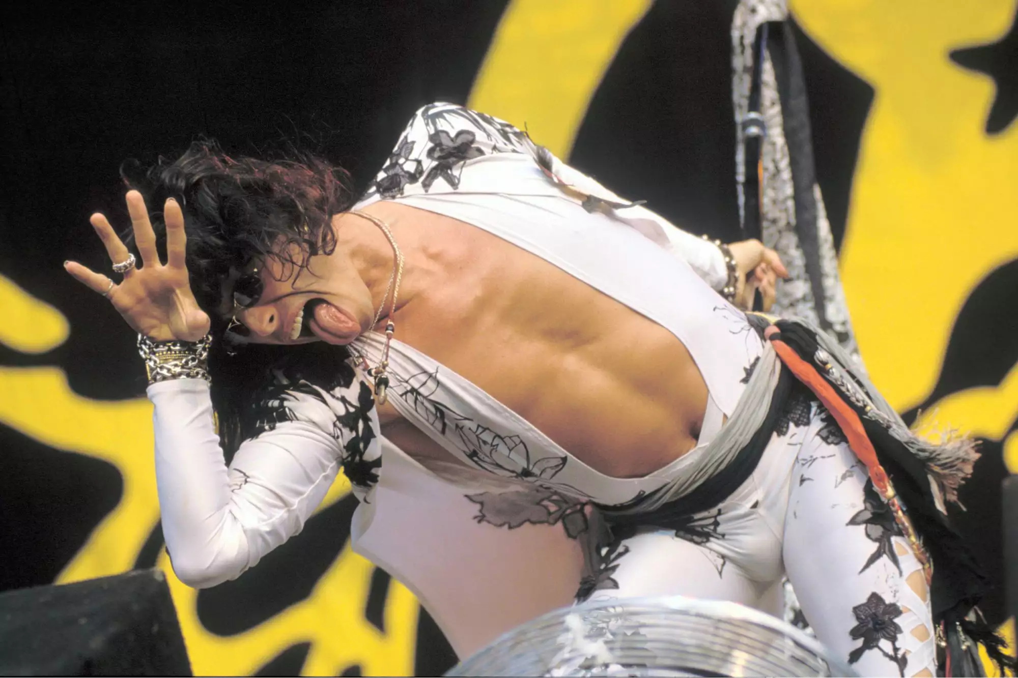 Steven Tyler’s Shocking Vocal Injury: His Final Bow & 5 Powerful Lessons for Singers a man in a white outfit with black and white design on it